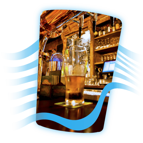 Half-drunk pint of beer on a bar in a pub